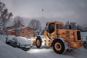 A snow-covered driveway freshly cleared by a snowplow with the Birchfield Landscape logo.