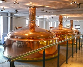 Close-up of copper stills gleaming under soft light, with gentle steam rising.