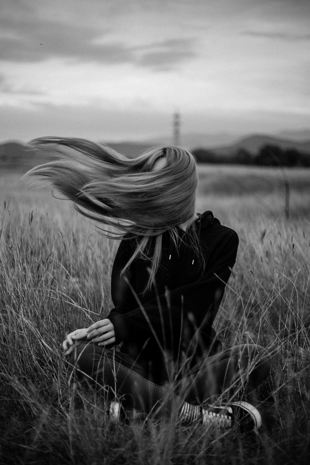 woman in black coat standing on grass field