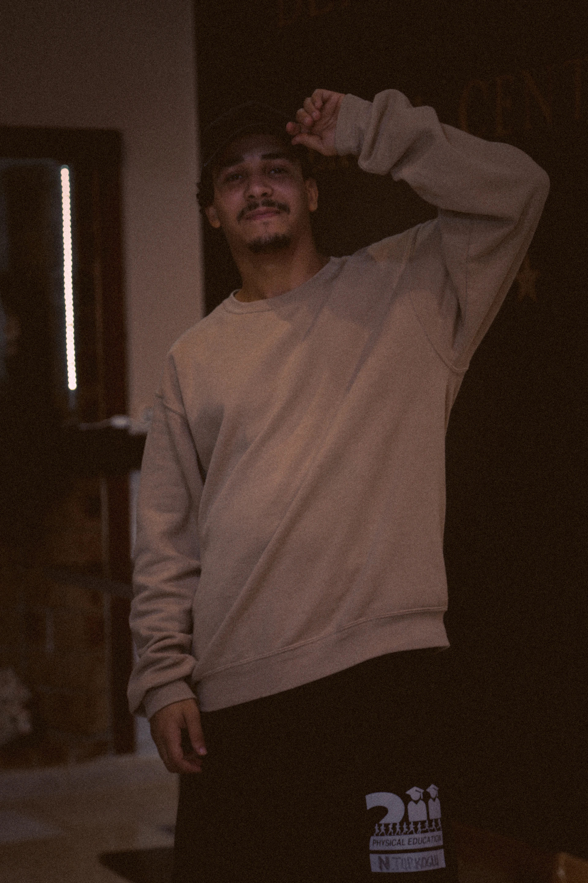 A casual outfit featuring a soft grey hoodie and dark jeans, perfect for relaxed weekend wear, set in a cozy café.