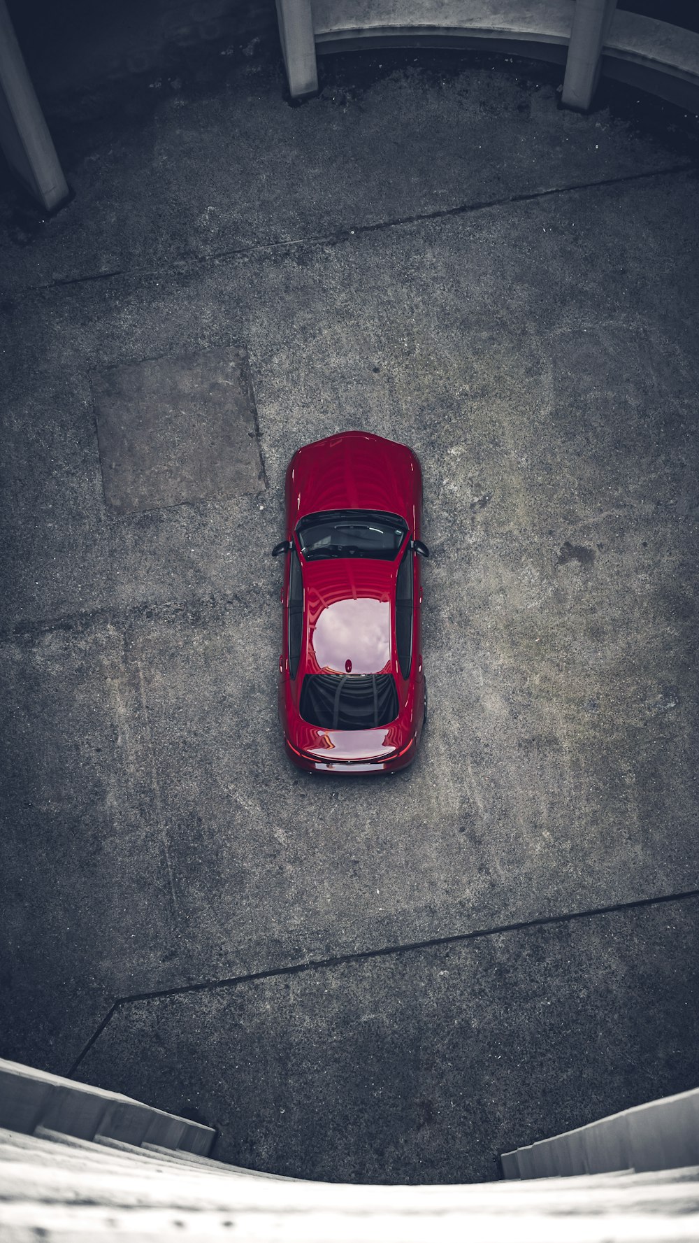 Auto rossa su strada asfaltata grigia