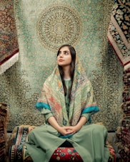 woman in blue and green dress sitting on brown and beige floral couch