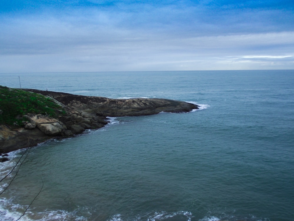 brown and green island in the middle of blue sea under blue sky during daytime