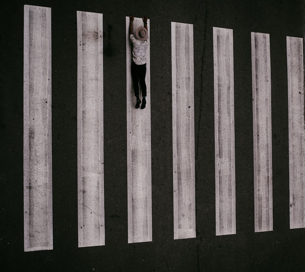 woman in black long sleeve shirt and black pants standing on black and white striped wall