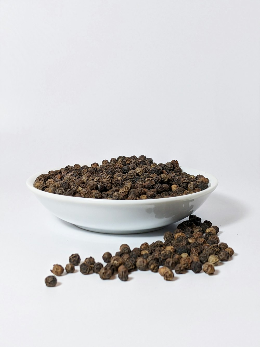 brown coffee beans on white ceramic bowl