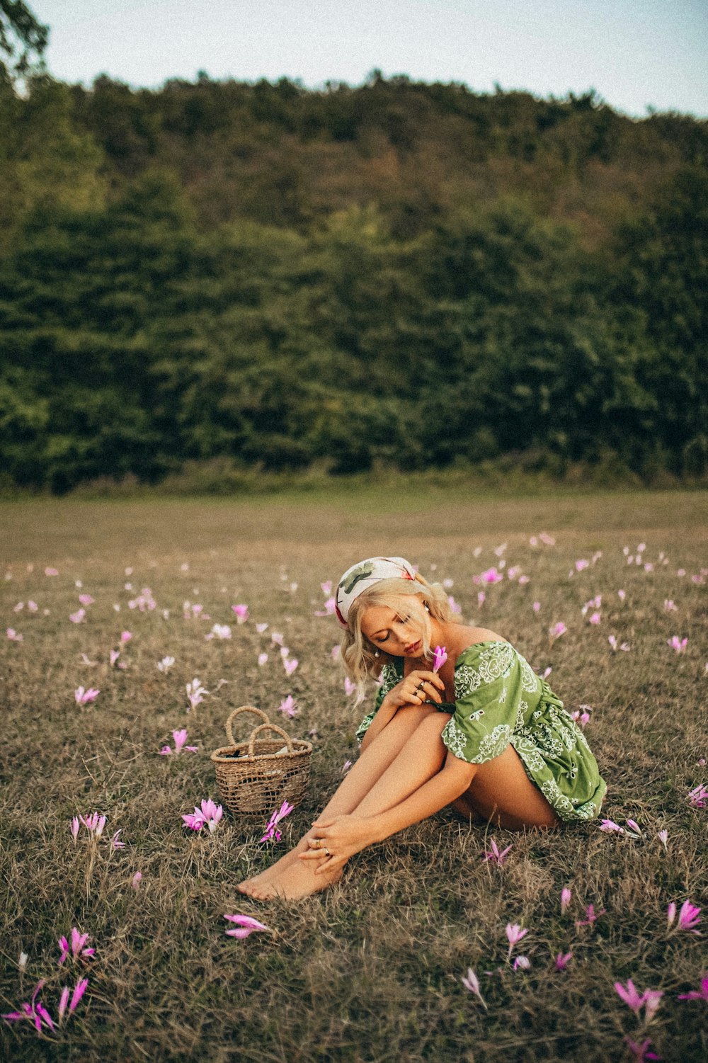 woman in green dress sitting on purple flower field during daytime