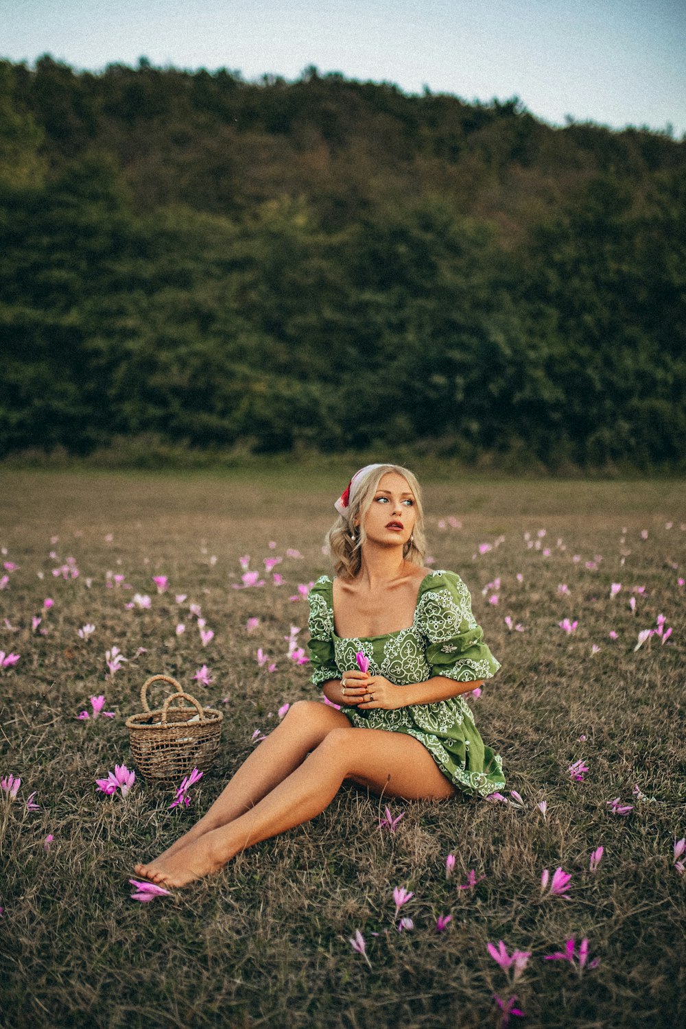 woman in green and white dress sitting on purple flower field during daytime