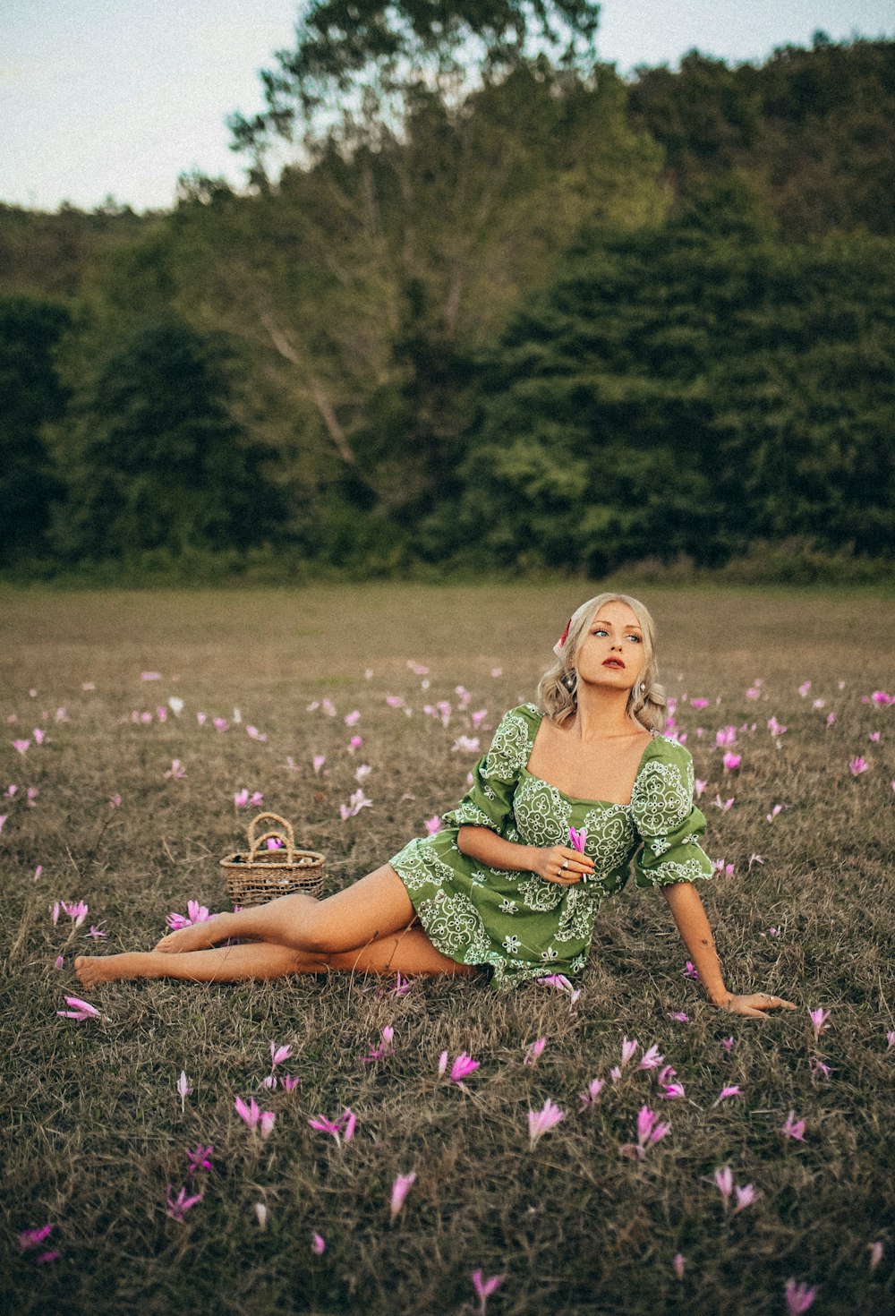 woman in green and white dress sitting on purple flower field during daytime