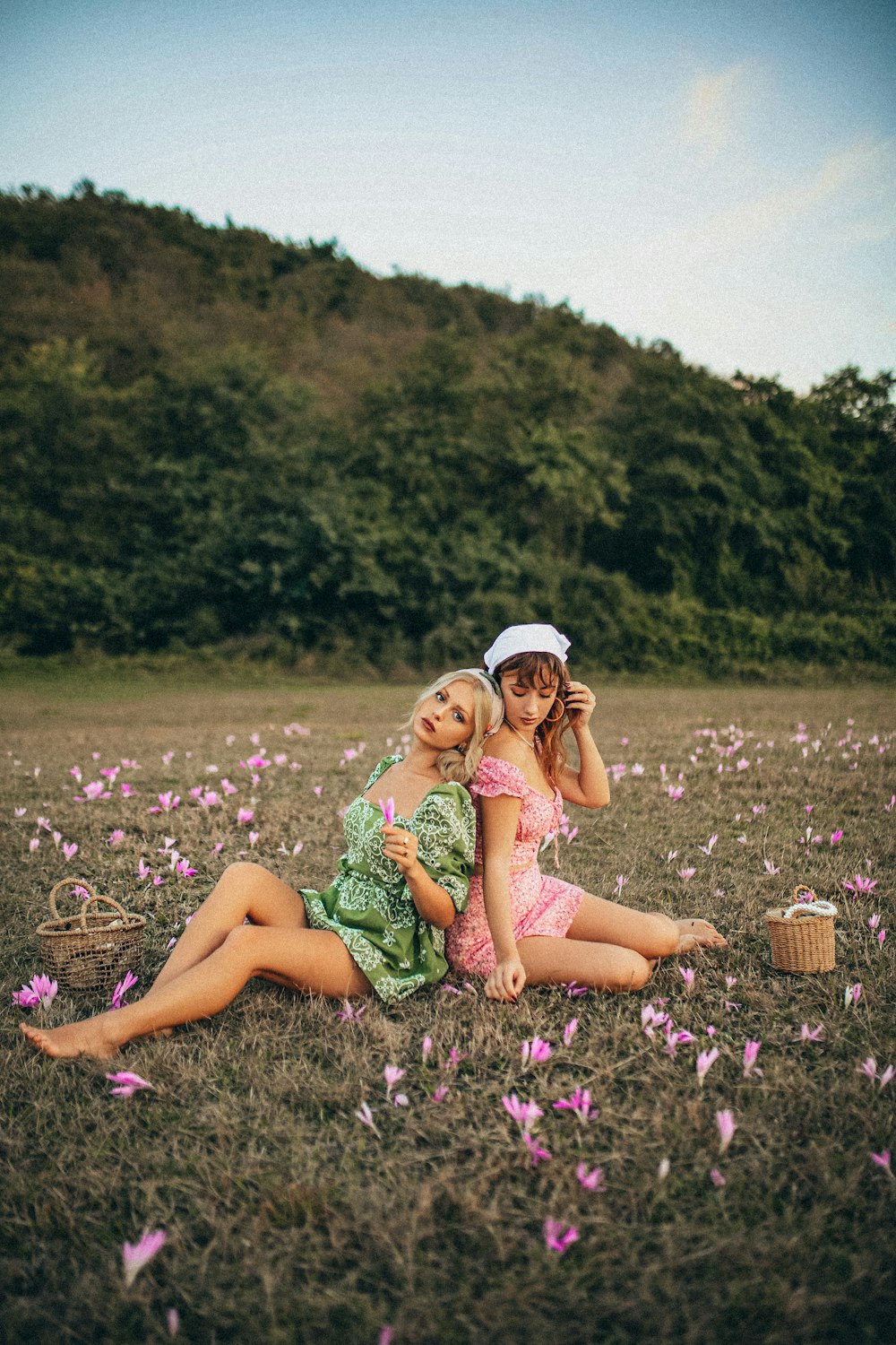 woman in green dress sitting on purple flower field during daytime