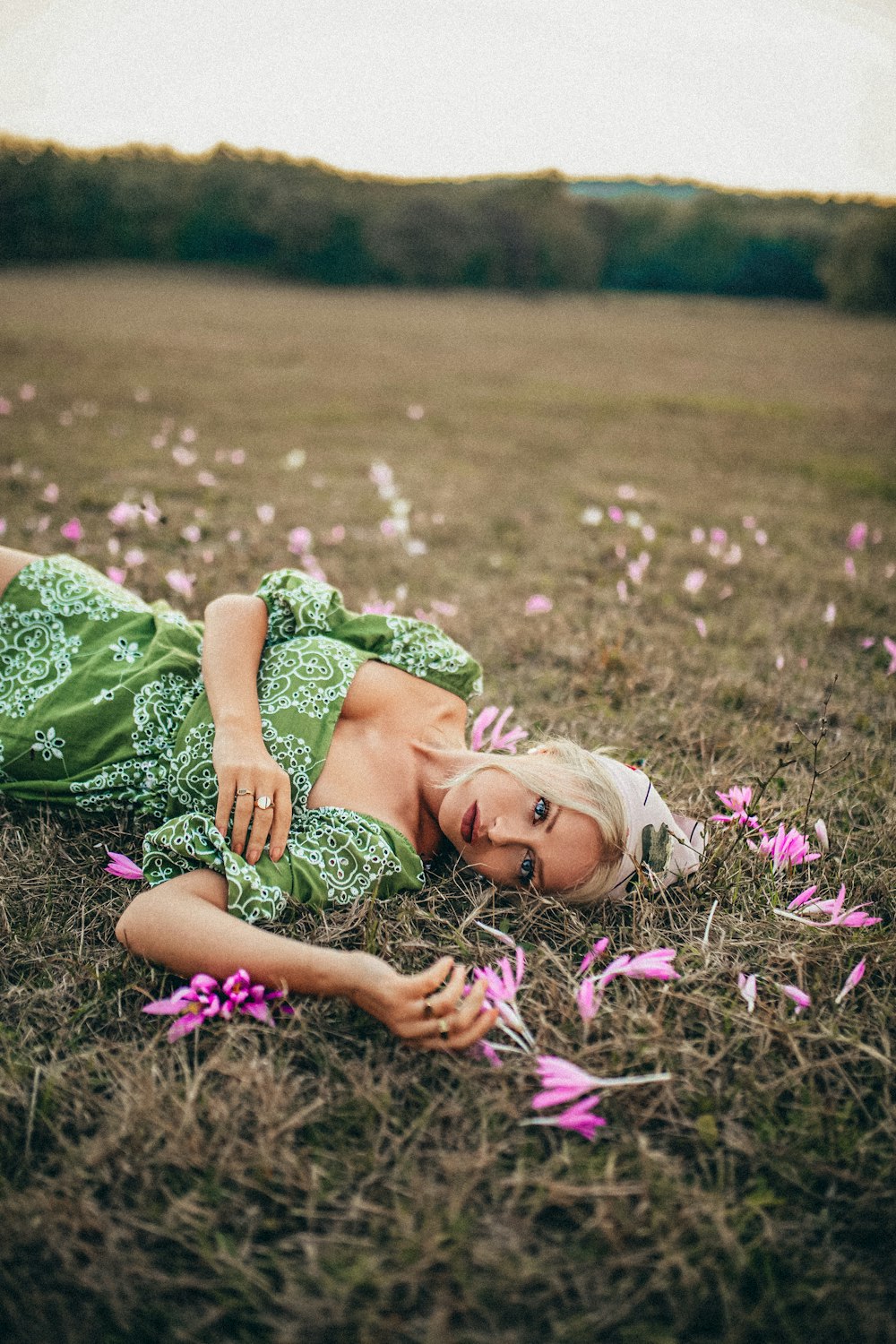 woman in green dress lying on grass field
