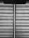 Horizontal blinds with a fabric texture are partially drawn, allowing a vertical sliver of light to pass through. A pull cord hangs from the upper portion of the blinds.