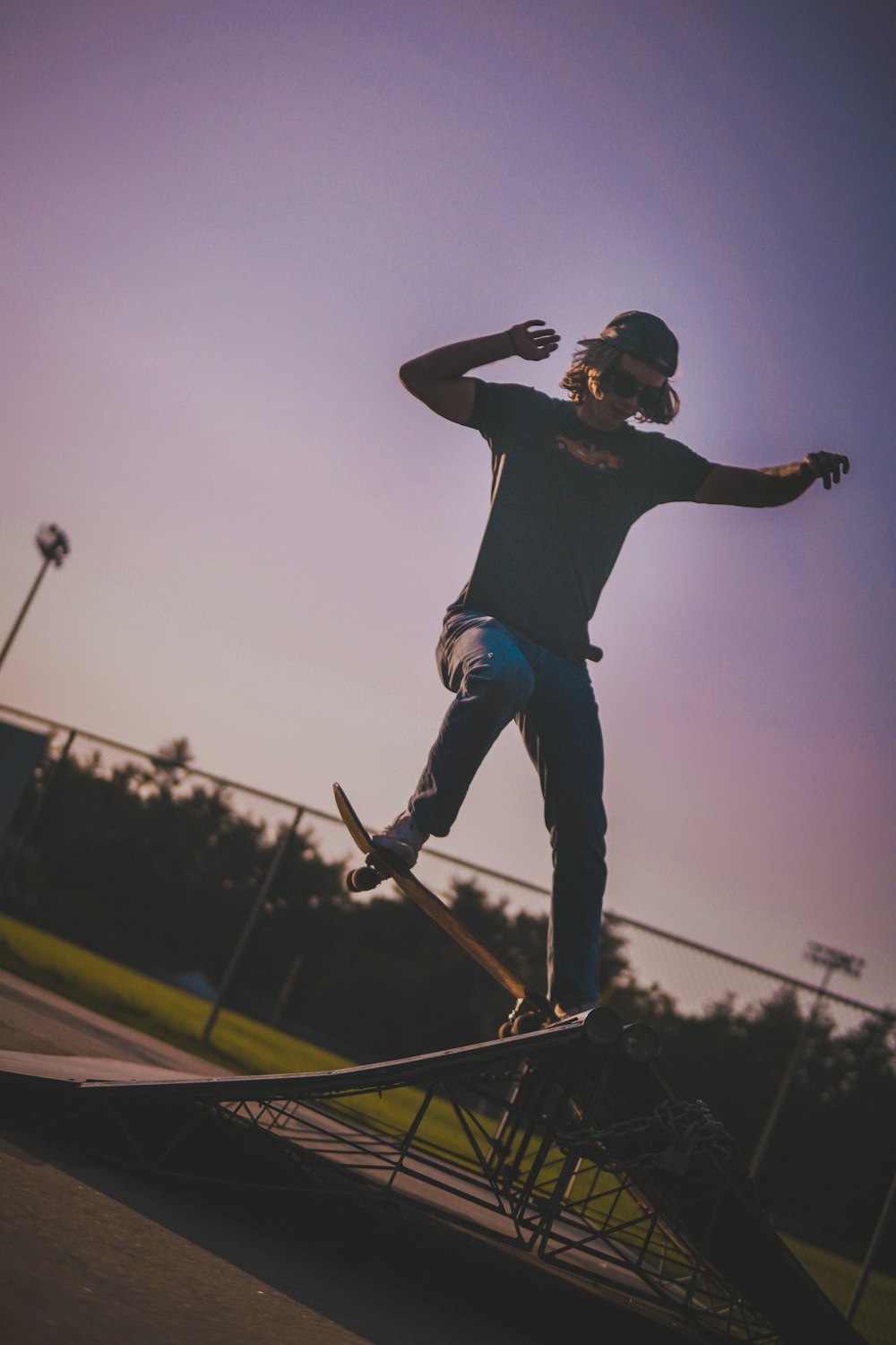 man in black shirt and blue denim jeans riding skateboard during daytime