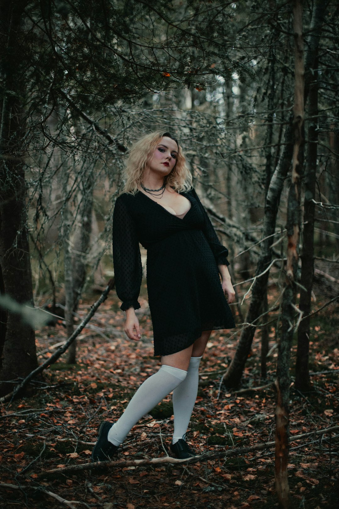 woman in black long sleeve dress standing on forest