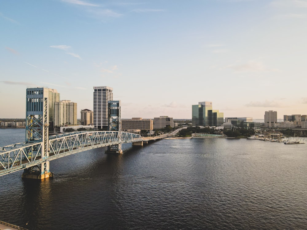 bridge over river near city buildings during daytime