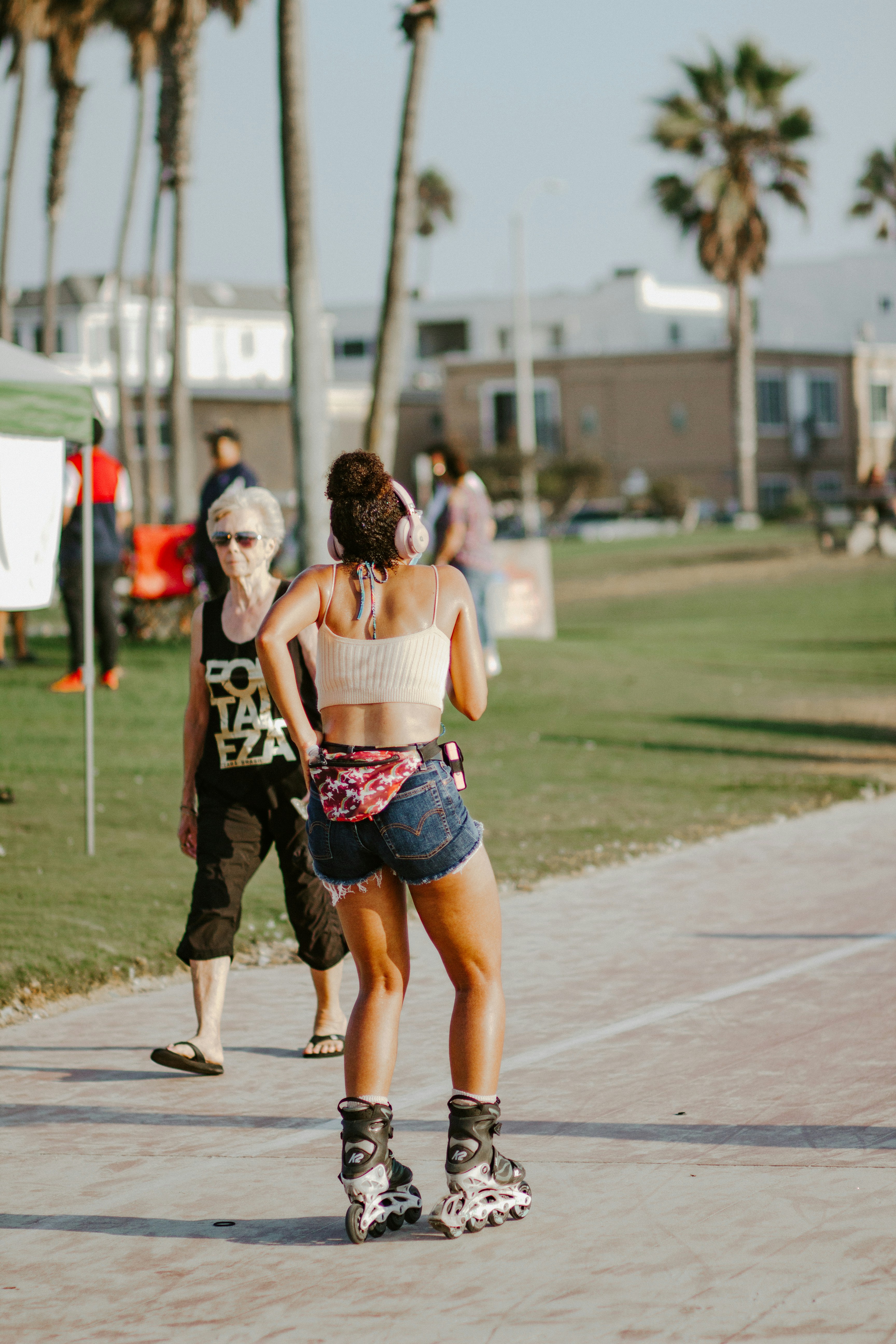woman in black and white floral skirt walking on street during daytime