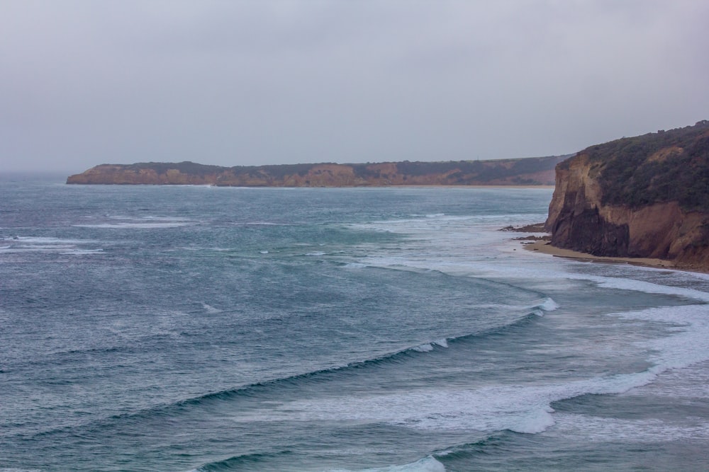 brown rock formation on sea during daytime