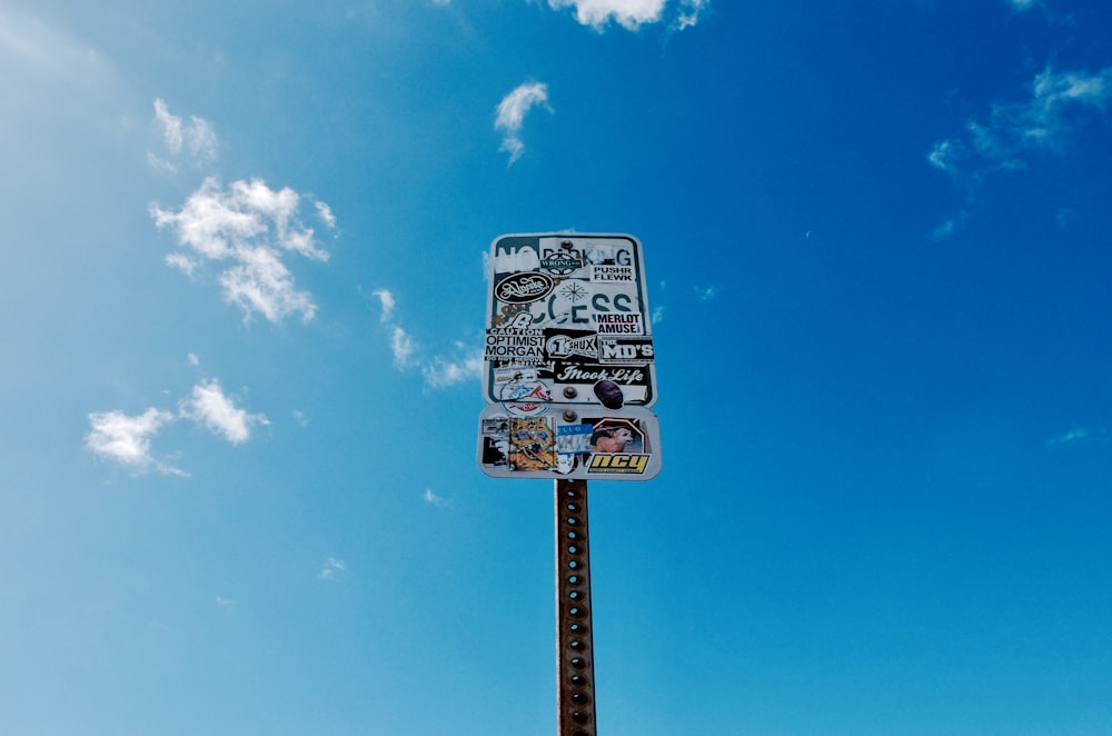 white and black street sign under blue sky during daytime