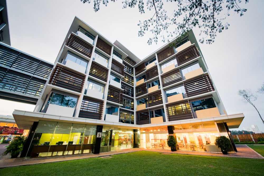 Edificio de hormigón blanco cerca de Green Grass Field durante el día