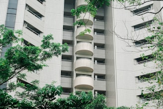 A modern residential building facade at arkade evoke Goregaon West with lush greenery around.