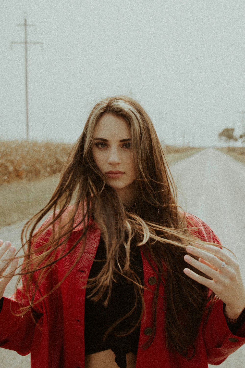 woman in red jacket standing on brown field during daytime