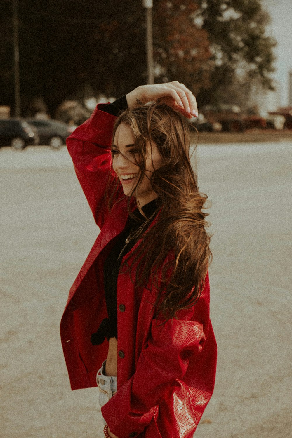 woman in red coat covering her face with her hair