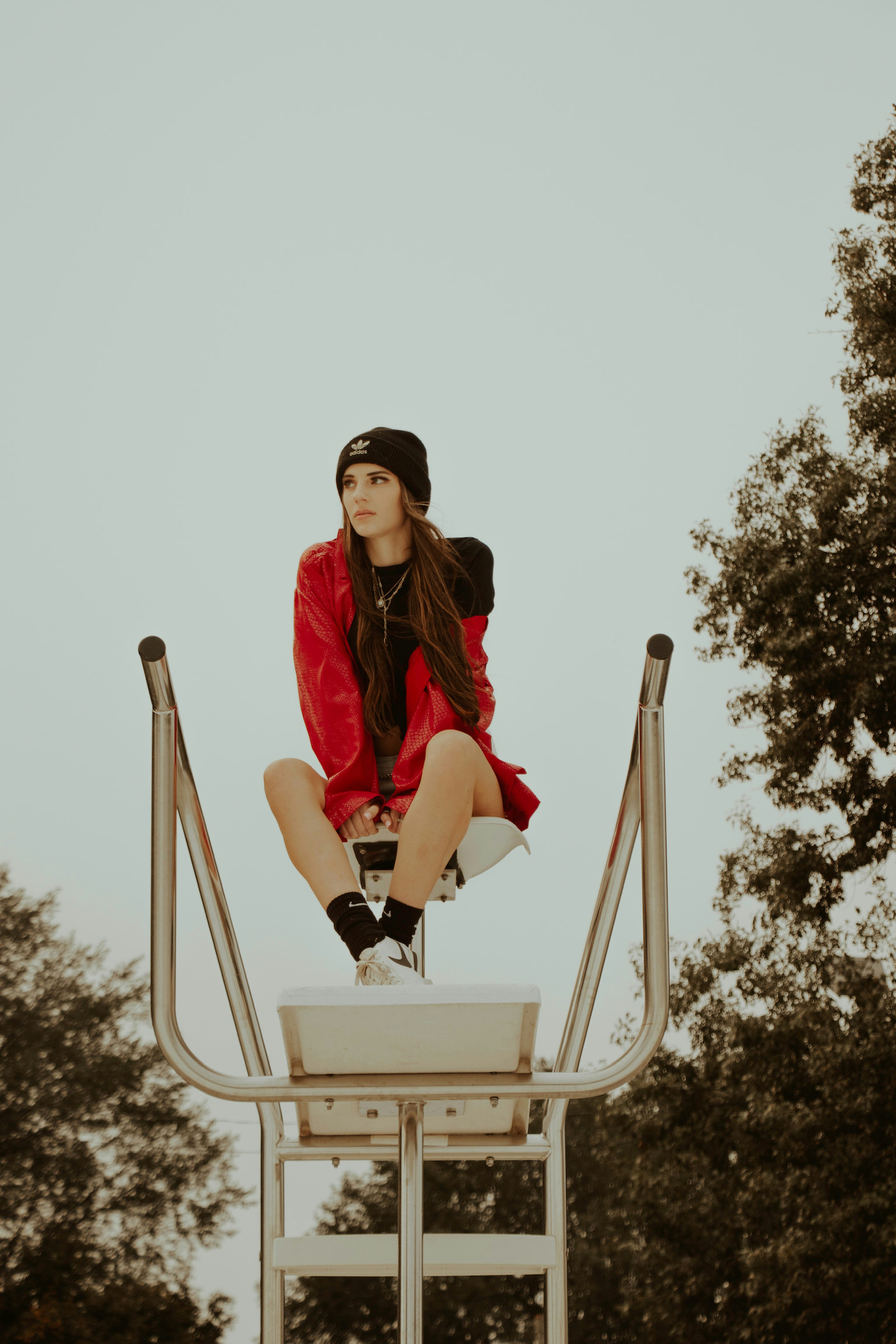 woman in red jacket sitting on white chair