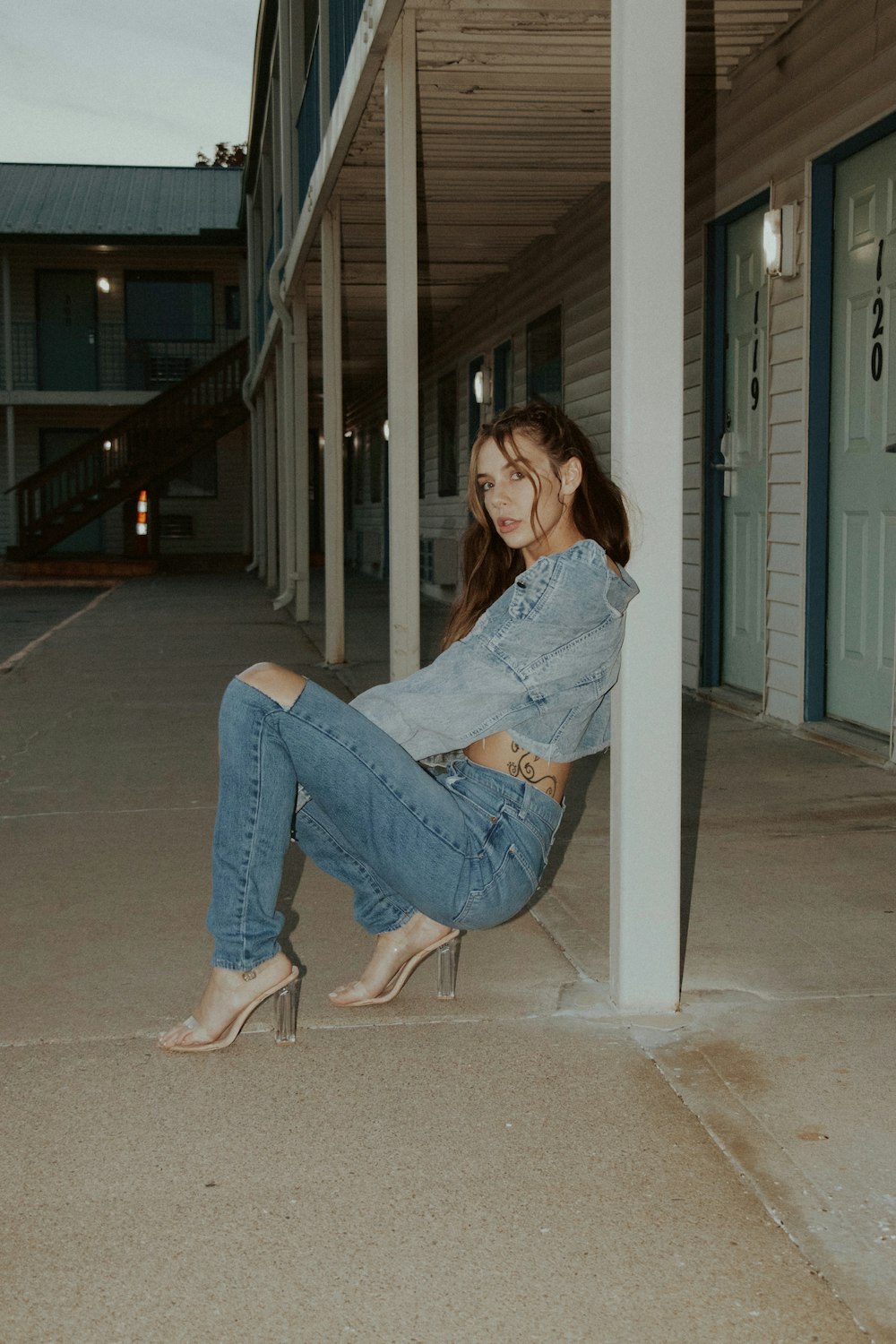 woman in blue denim jeans sitting on white chair