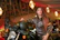 Photo of a happy woman standing next to her motorcycle, smiling confidently.