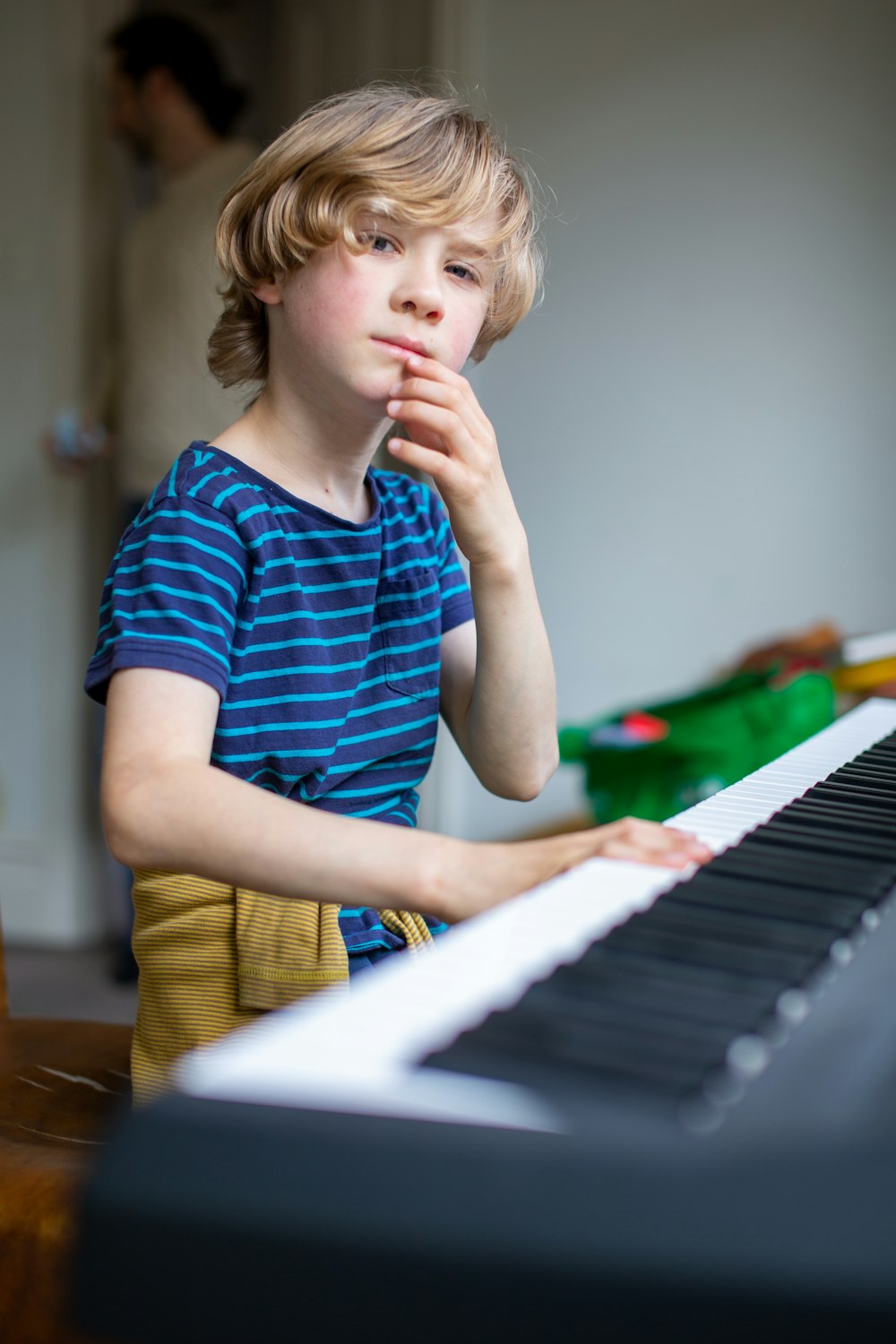 boy in blue and white stripe crew neck t-shirt playing piano