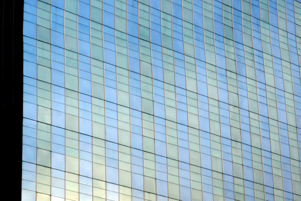 Close-up of a commercial building’s glass facade featuring a cool grey solar defense film that blends seamlessly with the slate-grey exterior.