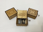 A happy customer winding up a music box, smiling as the melody starts.