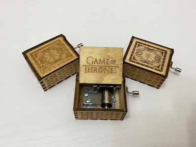 A polished wooden classic music box with intricate carvings and a winding key