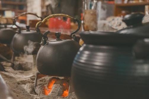 A warm kitchen scene where the betel group blends bubble up in a small batch roast over glowing coals.