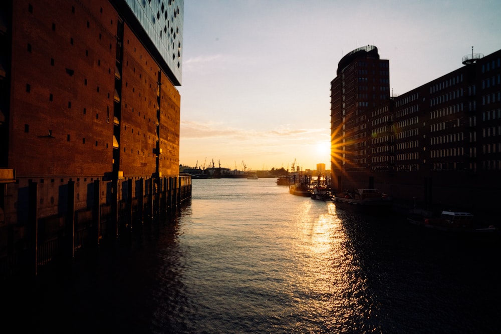 body of water between buildings during sunset
