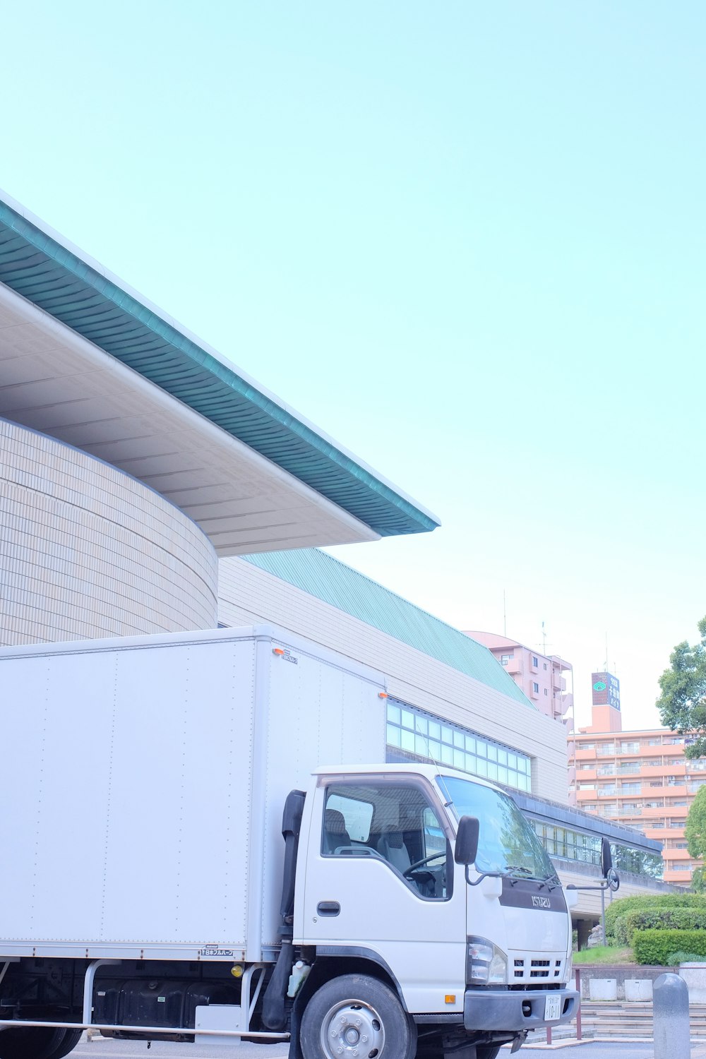 Furgoneta blanca estacionada cerca de un edificio blanco durante el día
