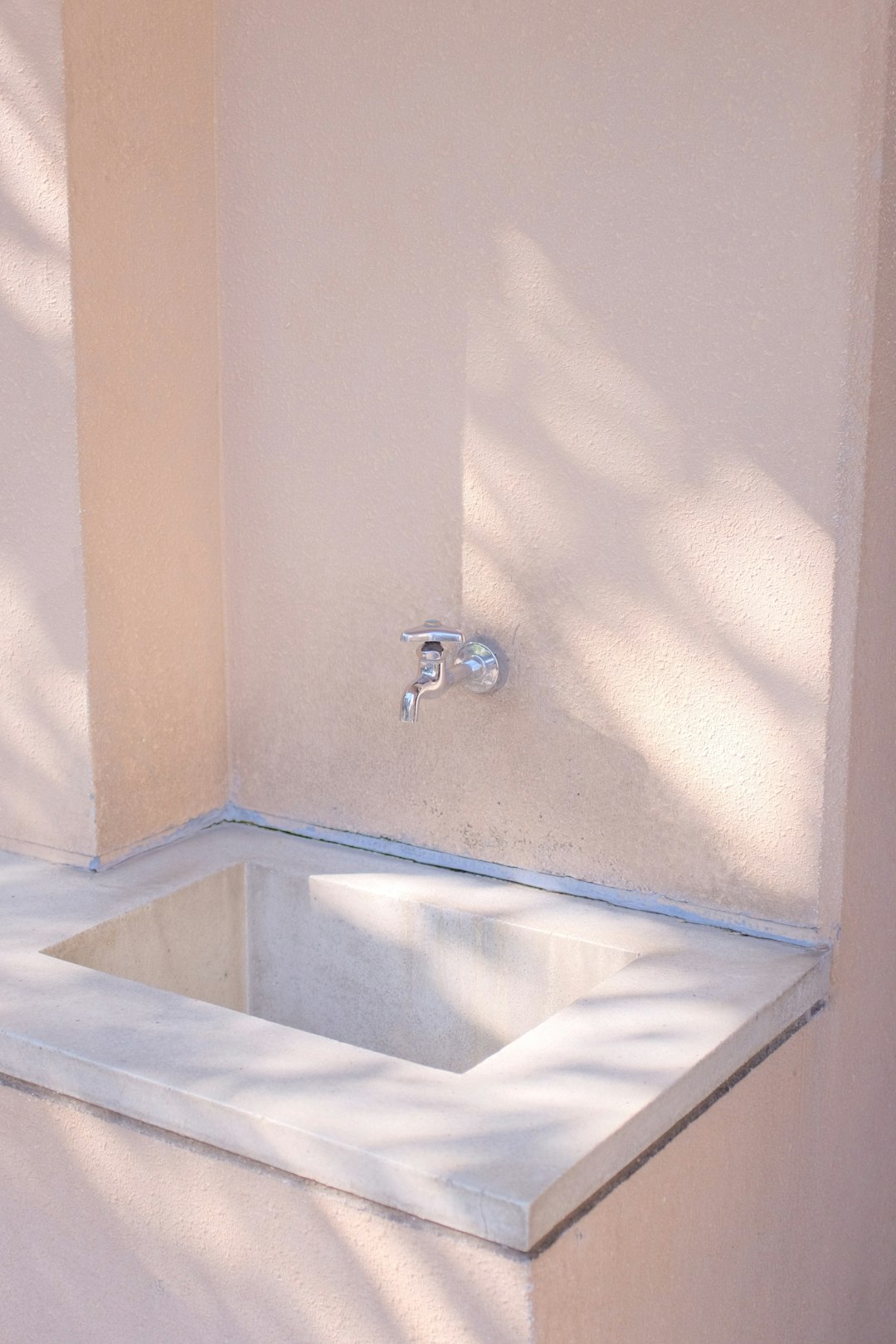 stainless steel faucet on white ceramic sink