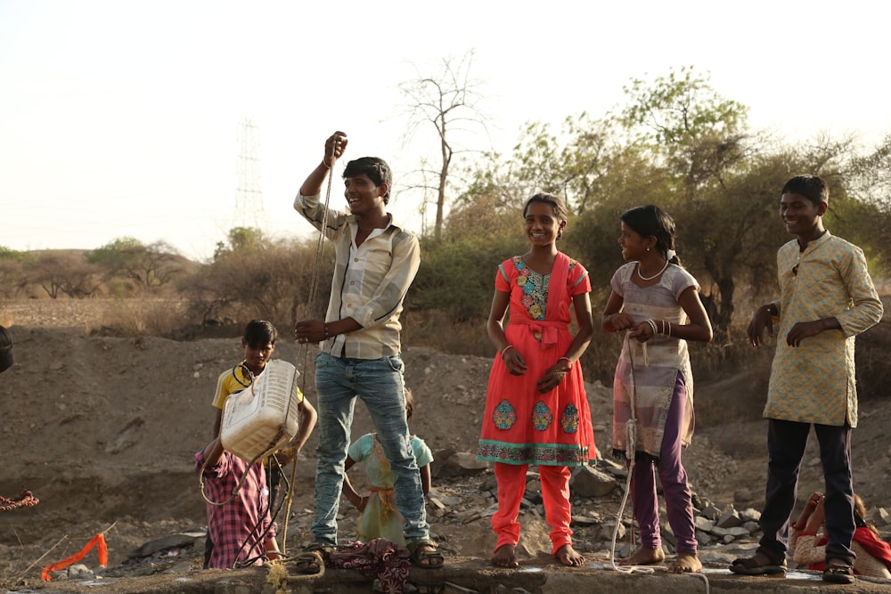 group of people standing on brown dirt ground during daytime