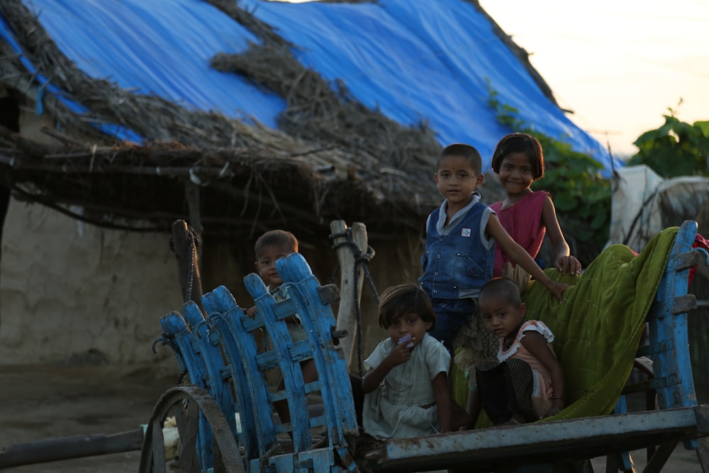 children sitting on wooden bench during daytime