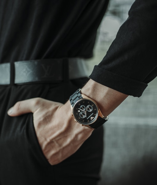 person wearing black round analog watch