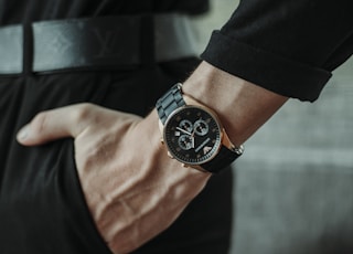 person wearing black round analog watch