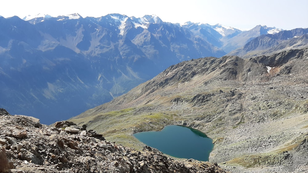 blue lake in the middle of green and white mountains