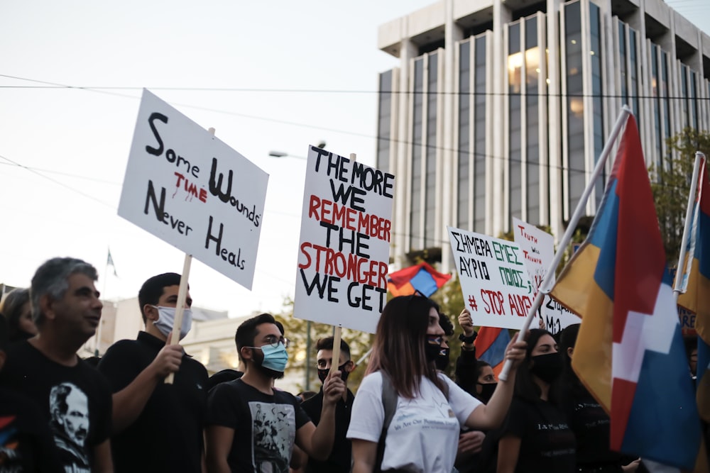 people holding white and blue banner during daytime