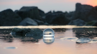 A serene landscape featuring a crystal ball reflecting the moonlight.