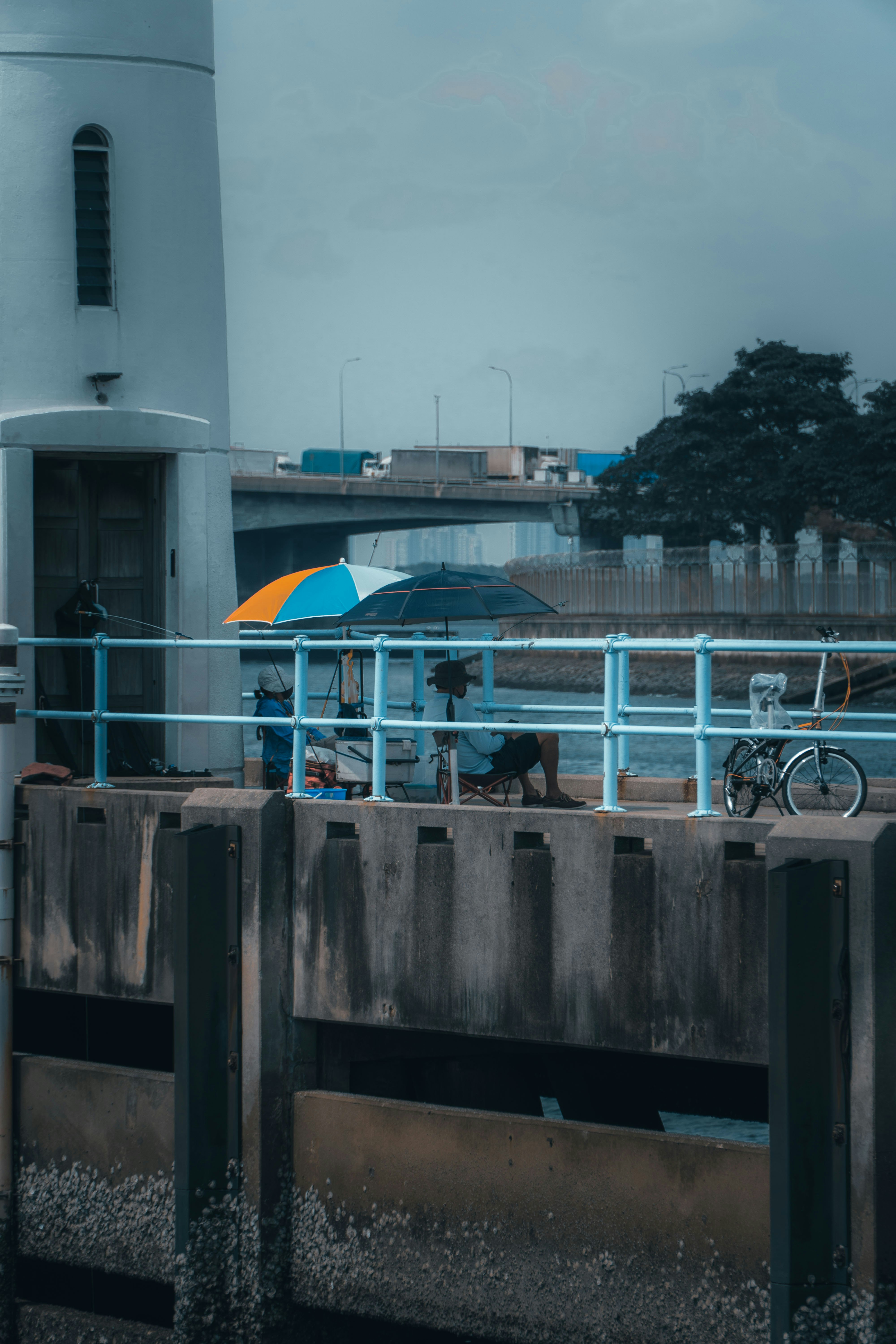 blue umbrella on black metal fence near white concrete building during daytime