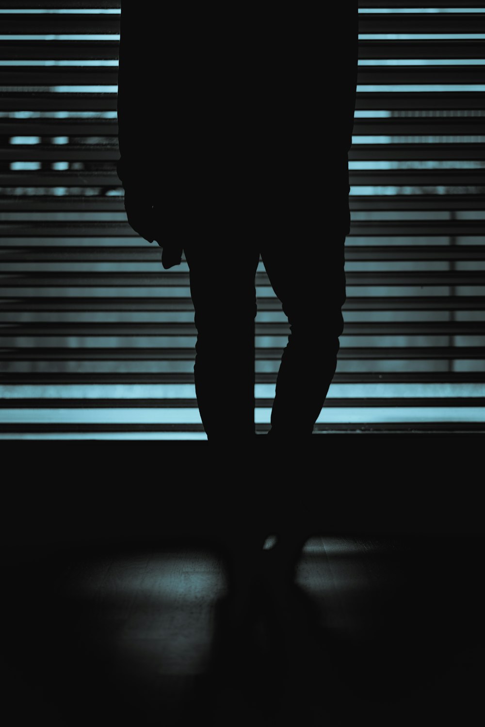 silhouette of person standing in front of window