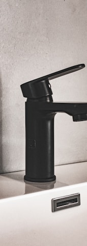 black and silver faucet on white ceramic sink