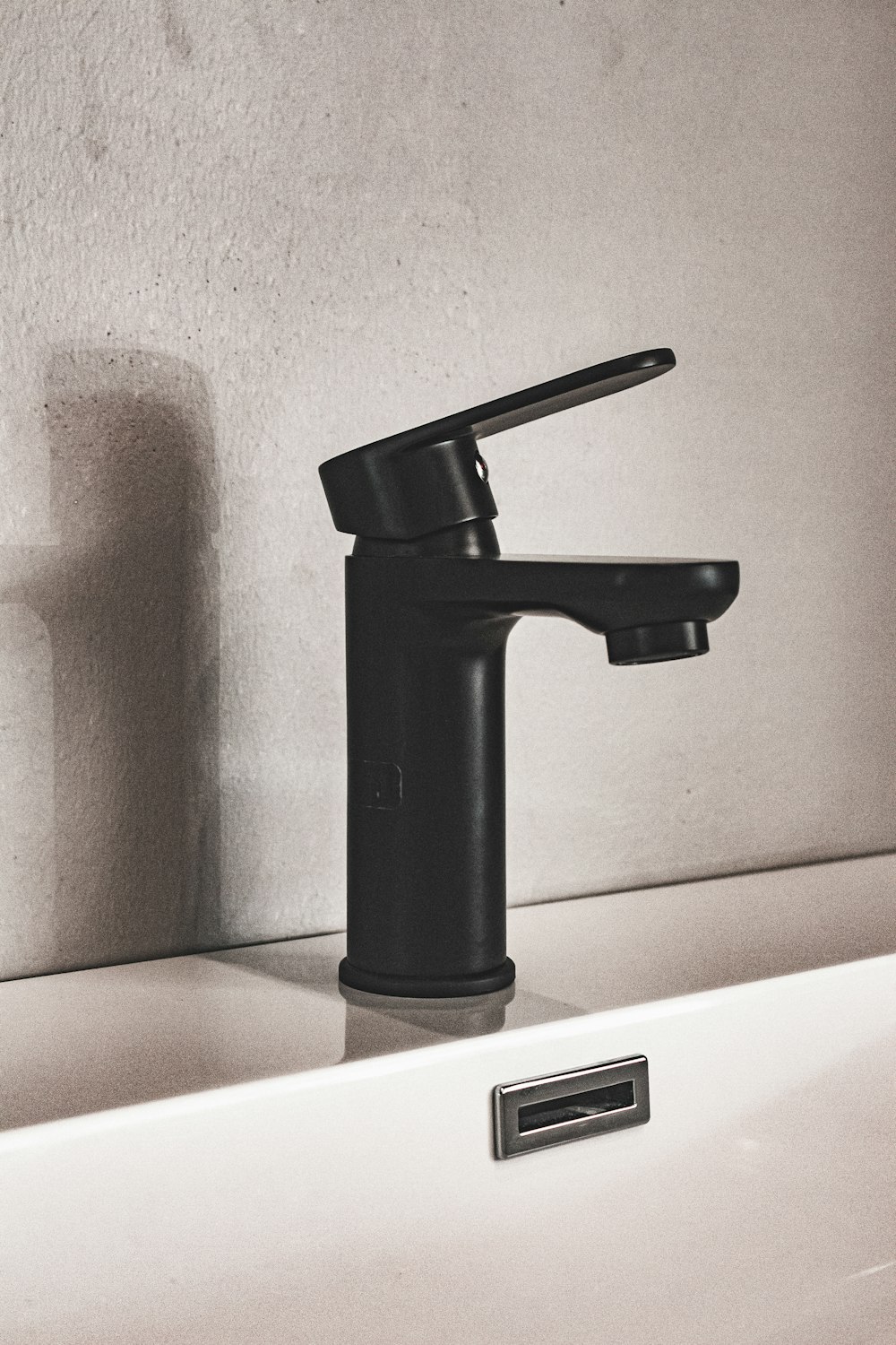 black and silver faucet on white ceramic sink