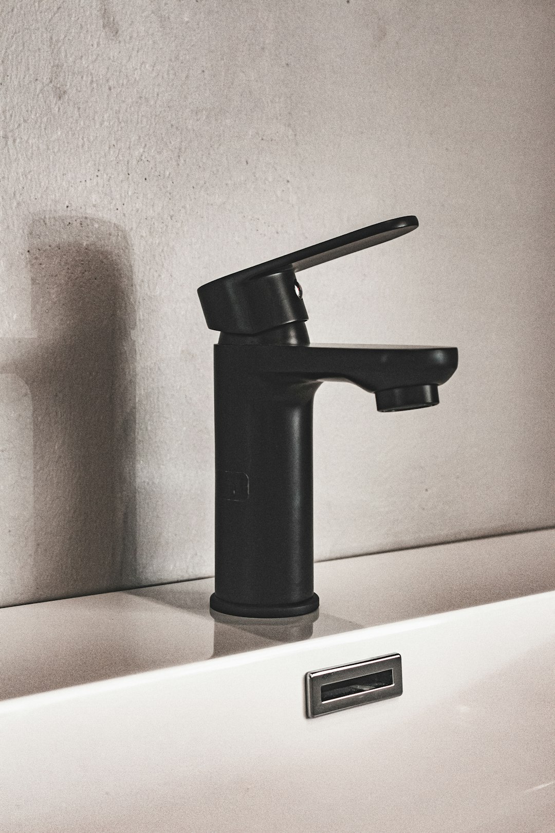  black and silver faucet on white ceramic sink tap