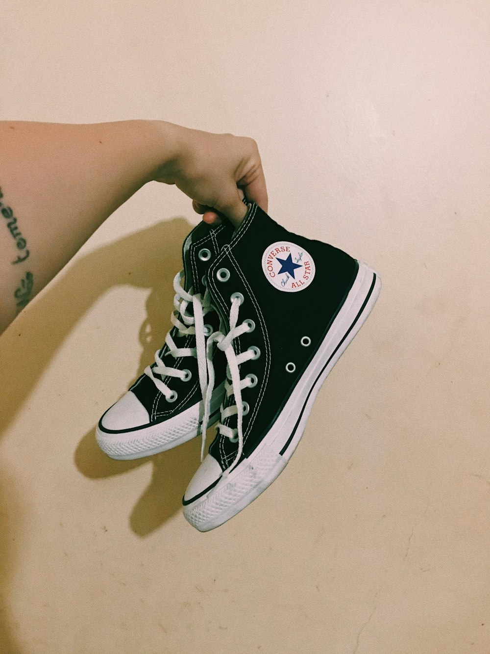Person trägt schwarze Converse All Star High Top Sneakers