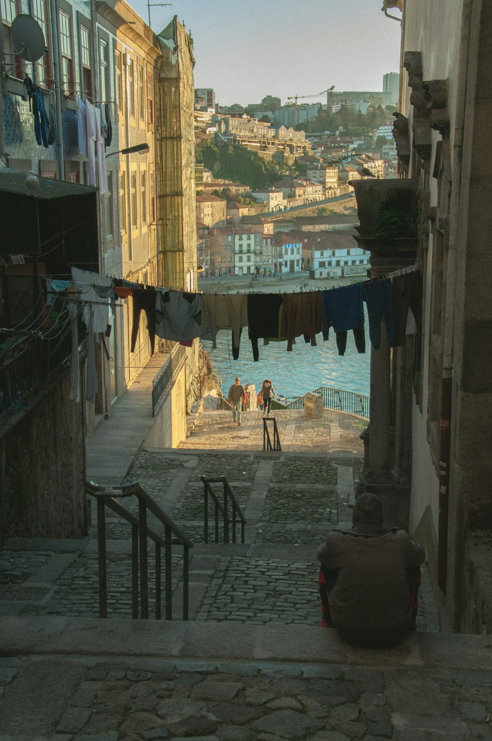 people walking on sidewalk near body of water during daytime